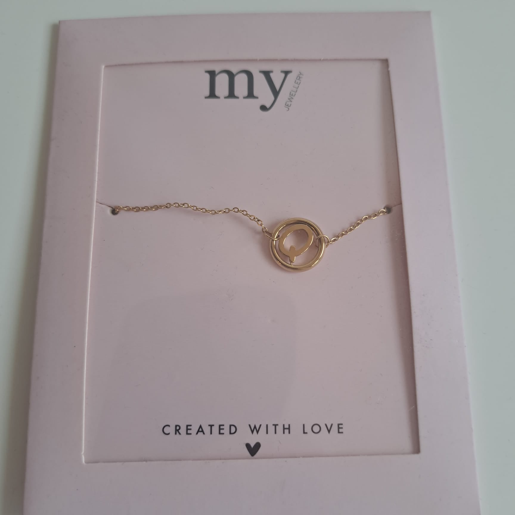Ein filigranes Armband mit einem kreisförmigen Anhänger der Marke My Jewellery, das auf einer Karte mit der Aufschrift „Created with love“ präsentiert wird